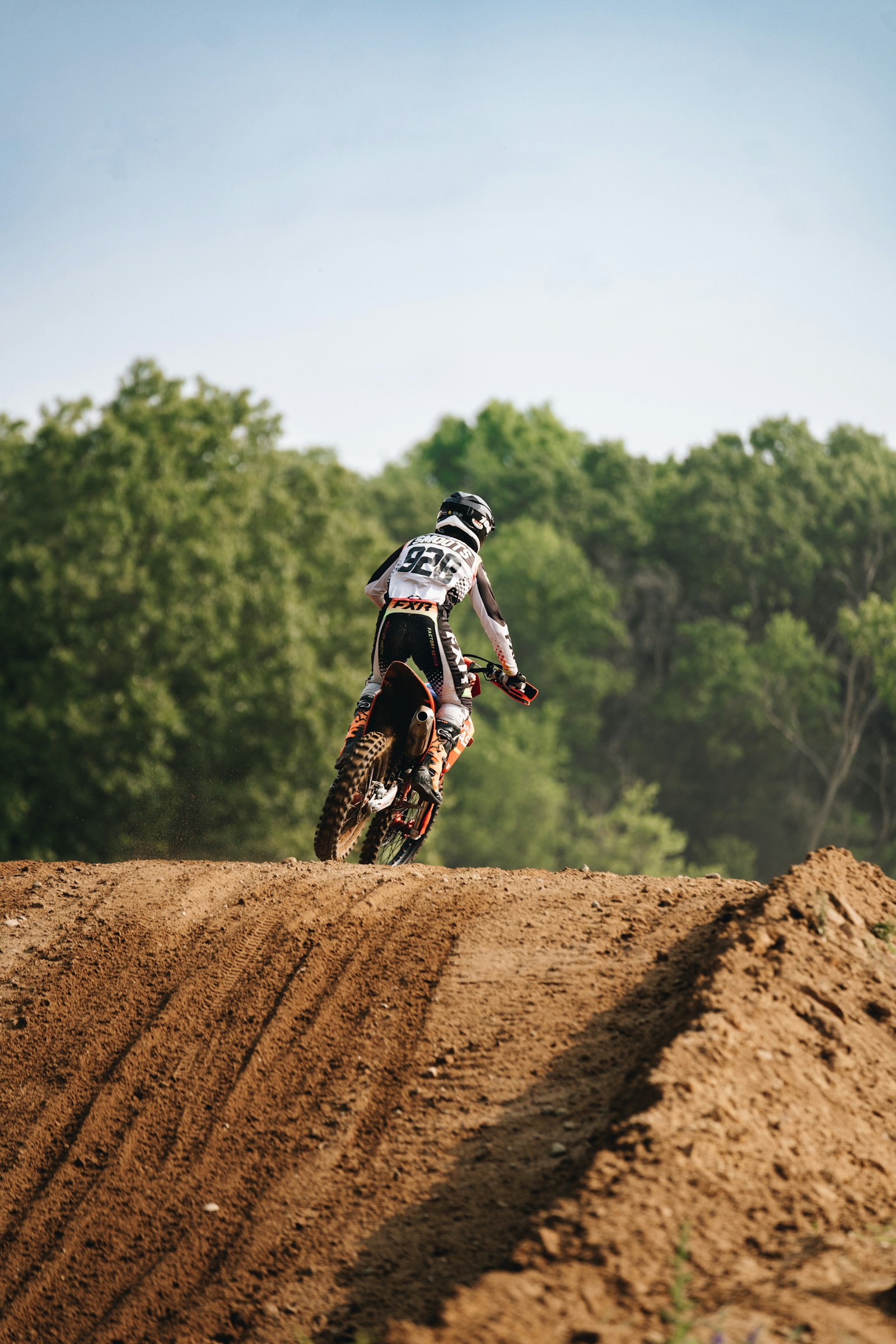 Illustrative motocross action above a dirt track